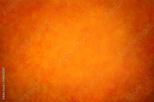 Orange bright background, textured wall with dark edges and a bright center.