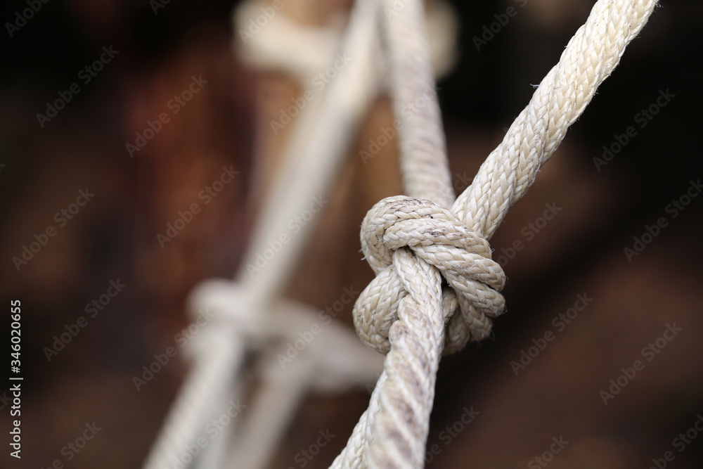 Large knot made of natural hemp. The know it part of kids' playground equipment in Switzerland. A know is a symbol for nautical life, cooperation, harmony, connection, being together, etc. Closeup.