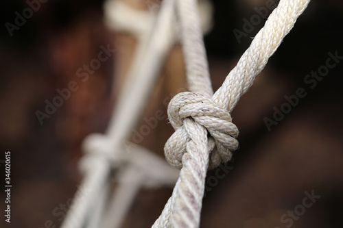 Large knot made of natural hemp. The know it part of kids' playground equipment in Switzerland. A know is a symbol for nautical life, cooperation, harmony, connection, being together, etc. Closeup.