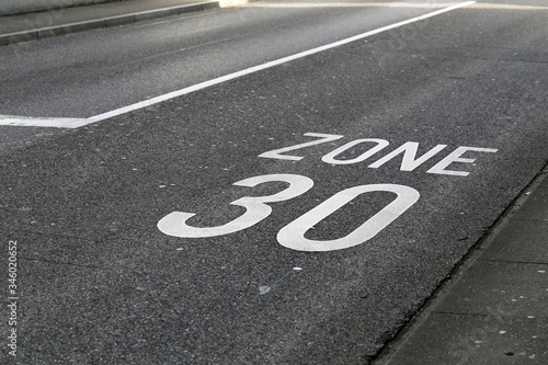 Asphalt driveway in Switzerland with 30km/h speed limit. Speed limit marked to road with text 