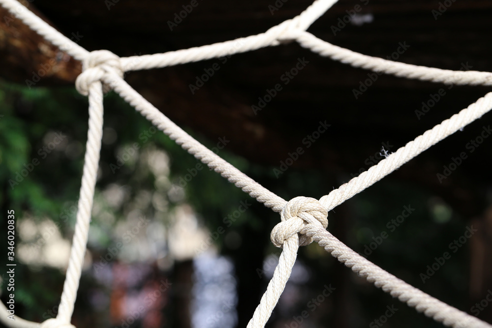 Large knot made of natural hemp. The know it part of kids' playground equipment in Switzerland. A know is a symbol for nautical life, cooperation, harmony, connection, being together, etc. Closeup. Large knot made of natural hemp. The know it part of kids' playground equipment in Switzerland. A know is a symbol for nautical life, cooperation, harmony, connection, being together, etc. Closeup.