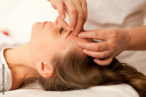 Young woman caring for her skin on the face makes massage