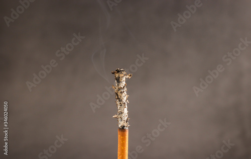 Burning cigarette on dark background 
