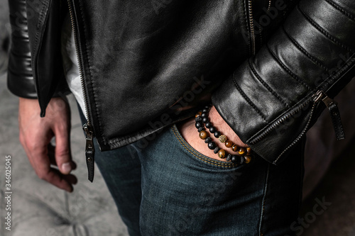 Fotografija Men's bracelets made of natural stones and minerals, close-up, on the hand
