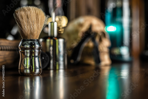 Shaving brush with chrome handle, on a wooden table, with beautiful bokeh