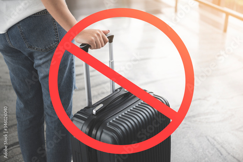 Stop travel in virus outbreak and trip-cancellation concept, Young woman carrying luggage with ignore icon photo