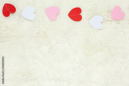 Wallpaper Mural Garland of white, pink and red paper hearts on milk white fur carpet from sheepskin, copy space, flat lay. St. Valentine's celebration, romantic concept Torontodigital.ca