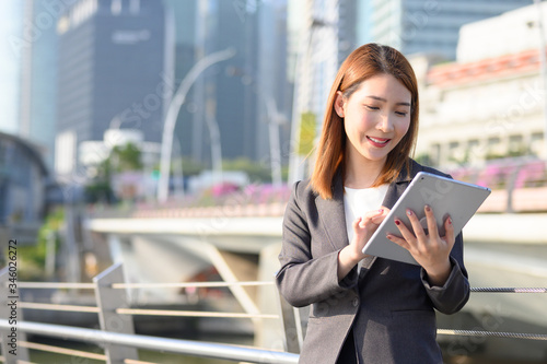 Canvas Print Young Asian business woman using laptop working in urban city