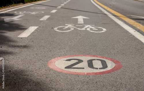 bicycle and speed limit signs on asphalt path © chechotkin