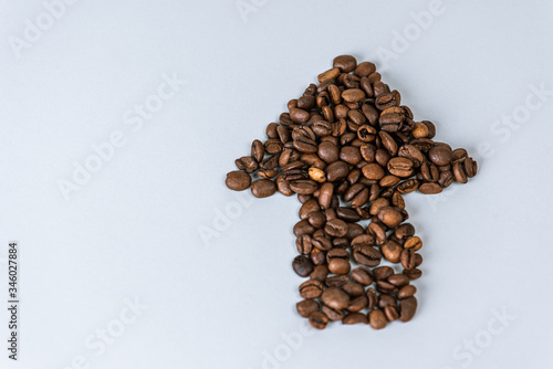 coffee beans scattered in the form of an arrow on a white isolated background