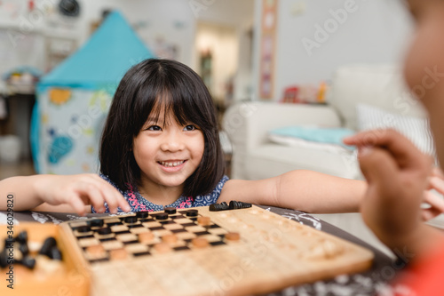 Asian kid girl and mother stay at home lockdown from covid-19 coronavirus crisis are playing chess while spending time together at home.Smart kid home school kid with mom.Stay home Stay safe with mom.