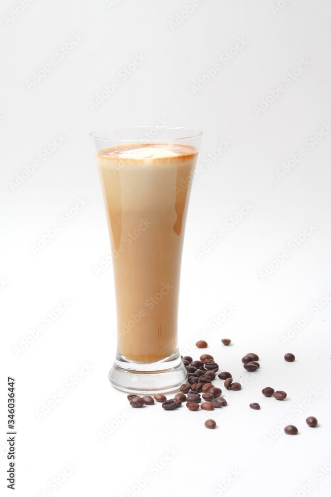 Latte Coffee In Glass And Coffee Beans Covered On White Background. Vertical Orientation, Side View, Copy Space. Latte Coffee In Glass And Coffee Beans Covered On White Background. Vertical Orientation, Side View, Copy Space.