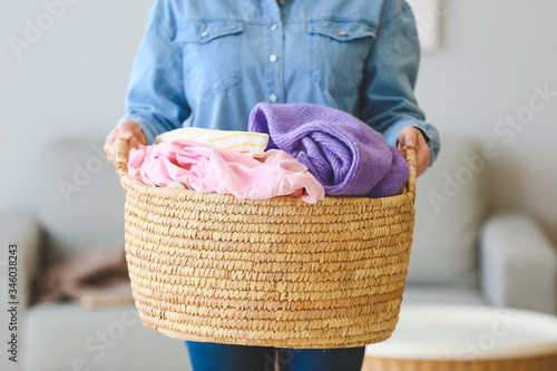 Tableau sur toile Woman with basket of laundry at home