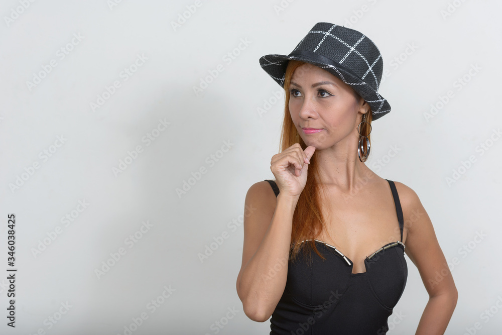Portrait of mature Asian woman with hat thinking Portrait of mature Asian woman with hat thinking