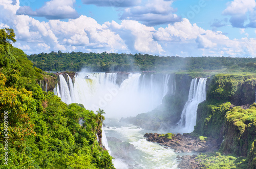 Iguazu waterfalls in Argentina  view from Devil s Mouth. Panoramic view of many majestic powerful water cascades with mist and splashes. Panoramic image of Iguazu riverside  river valley from above.