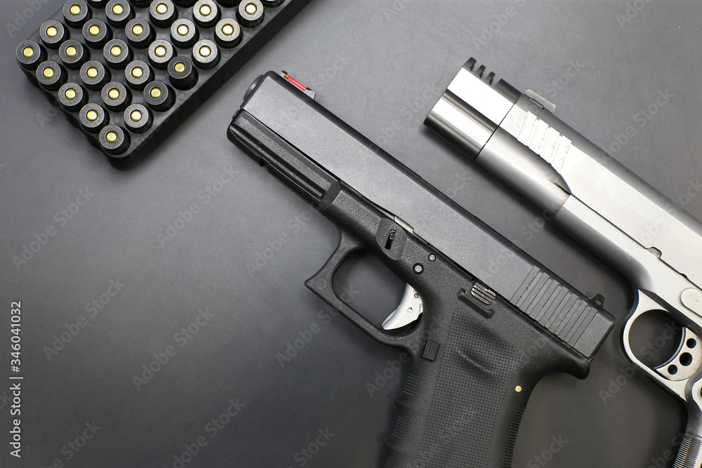 Gun with ammunition on black background. top view