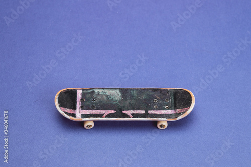 Small skateboard on blue background. tiny skate for fingers. fingerboard close up