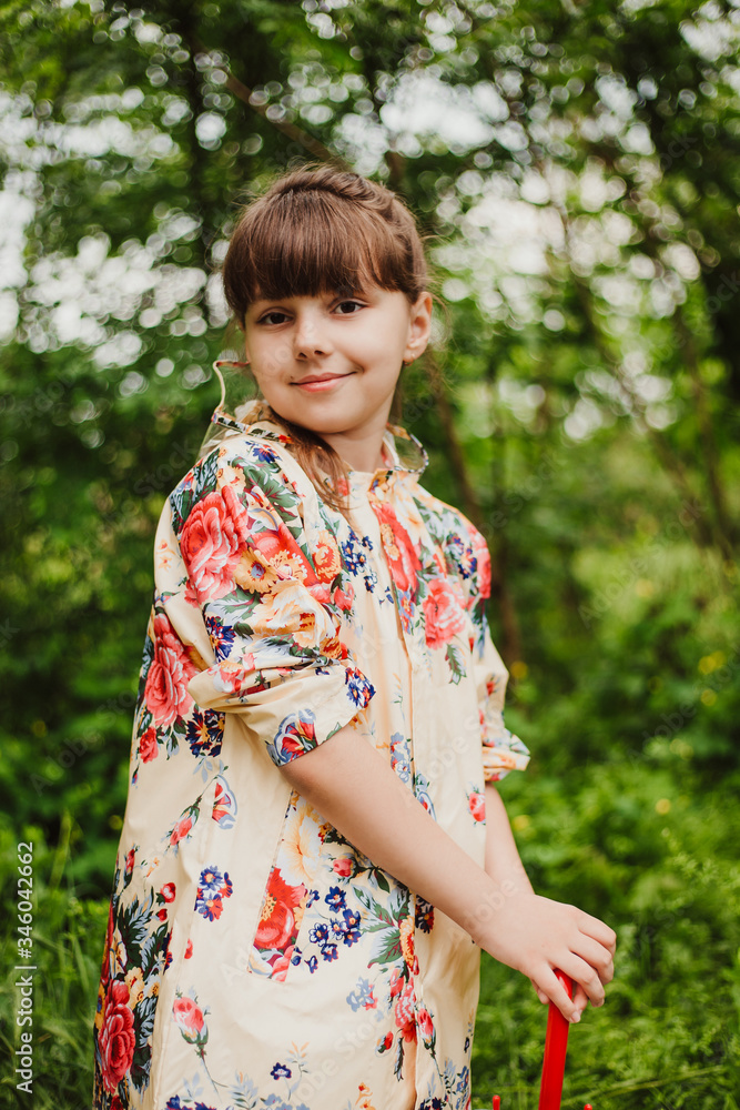 A beautiful girl in a bright raincoat walks during the rain under an umbrella. Soft focus A beautiful girl in a bright raincoat walks during the rain under an umbrella. Soft focus