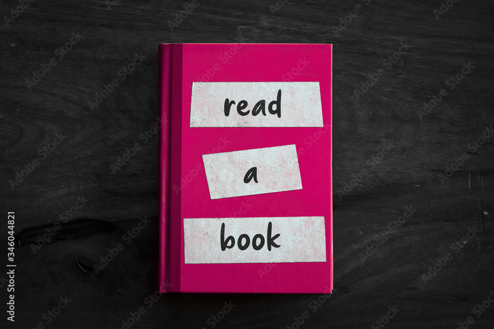 Obraz premium A pink book with a simple three worded message written on the front. 