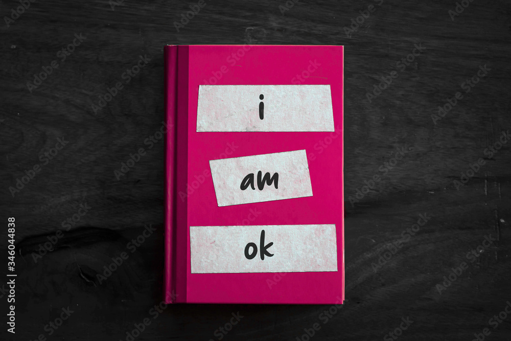 A pink book with a simple three worded message written on the front. A pink book with a simple three worded message written on the front.