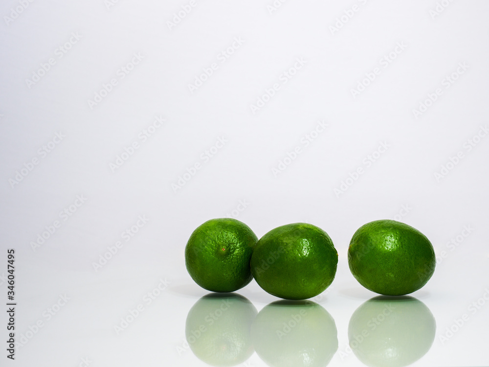 three limes with reflections on white background three limes with reflections on white background