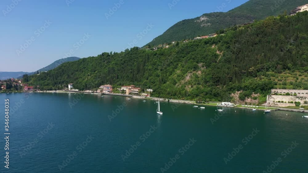 erial view of the church, the city of Toscolano Maderno, Lake Garda, Italy. White sailboat on a background of mountains erial view of the church, the city of Toscolano Maderno, Lake Garda, Italy. White sailboat on a background of mountains