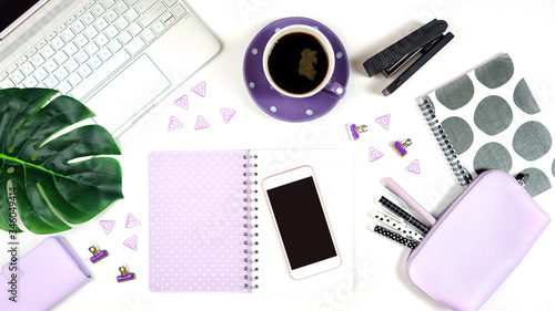 Desktop workspace flat lay with hi-tech touch screen laptop and modern purple, black and white accessories on white background.