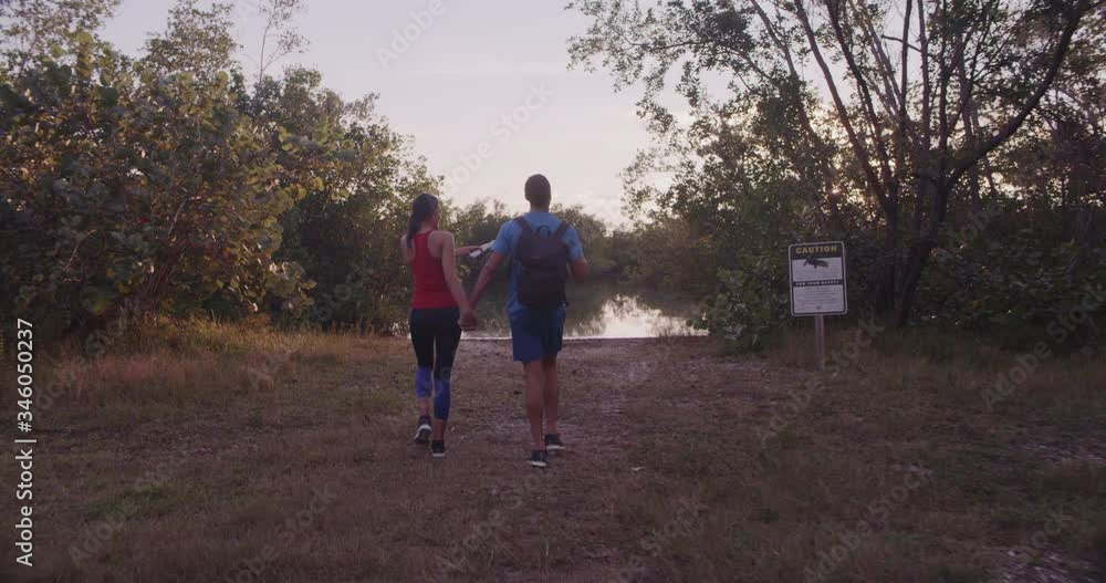 Athletic couple walking together on trail Athletic couple walking together on trail