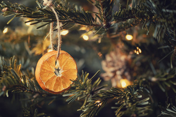 Zero waste christmas concept. Christmas tree decorated with ornaments made of natural materials - slices of dried orange and cones