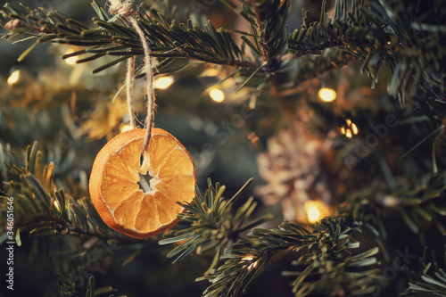 Zero waste christmas concept. Christmas tree decorated with ornaments made of natural materials - slices of dried orange and cones