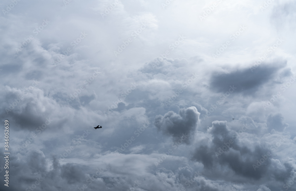 Small plane in cloudy sky for rainmaking. White fluffy clouds with