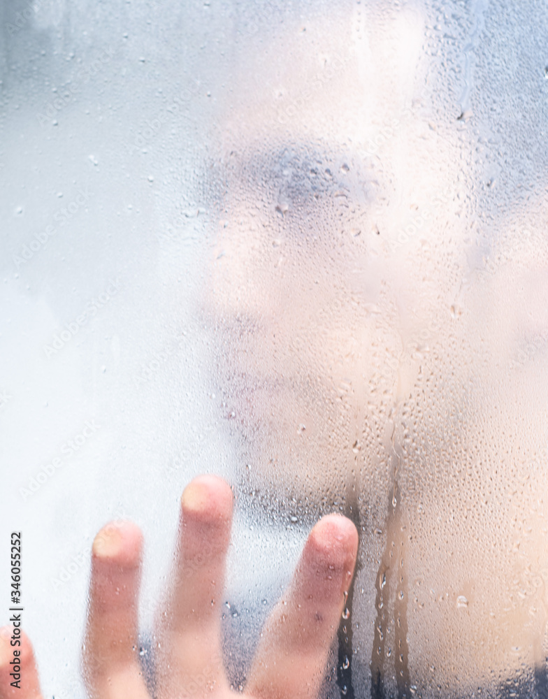 Fototapeta premium man behind the window while it rains 