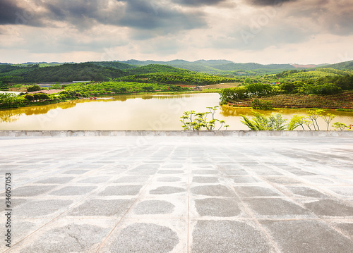 Unmanned floor tiles square platform and rural lake sunset landscape.