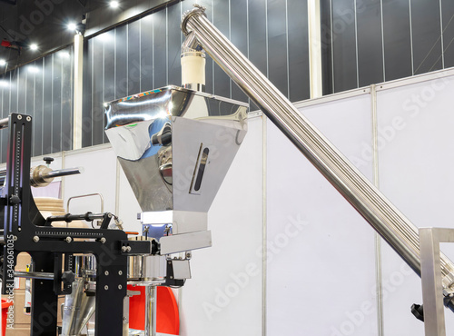 Stainless hopper and screw feeder system as parts of machine for storage and supply raw material before processing in packing process