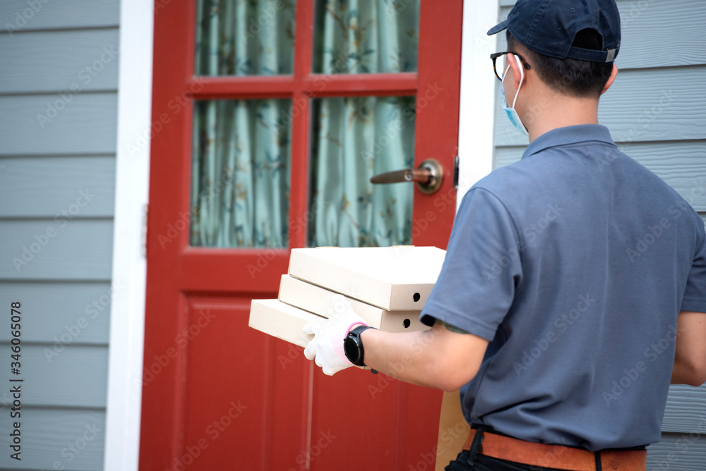 Delivery person holding a paper bag with food. Delivery to home. Delivery person in protective mask.