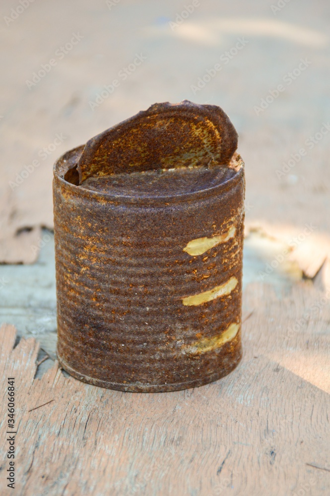Naklejka premium close up old rusty can on wooden floor