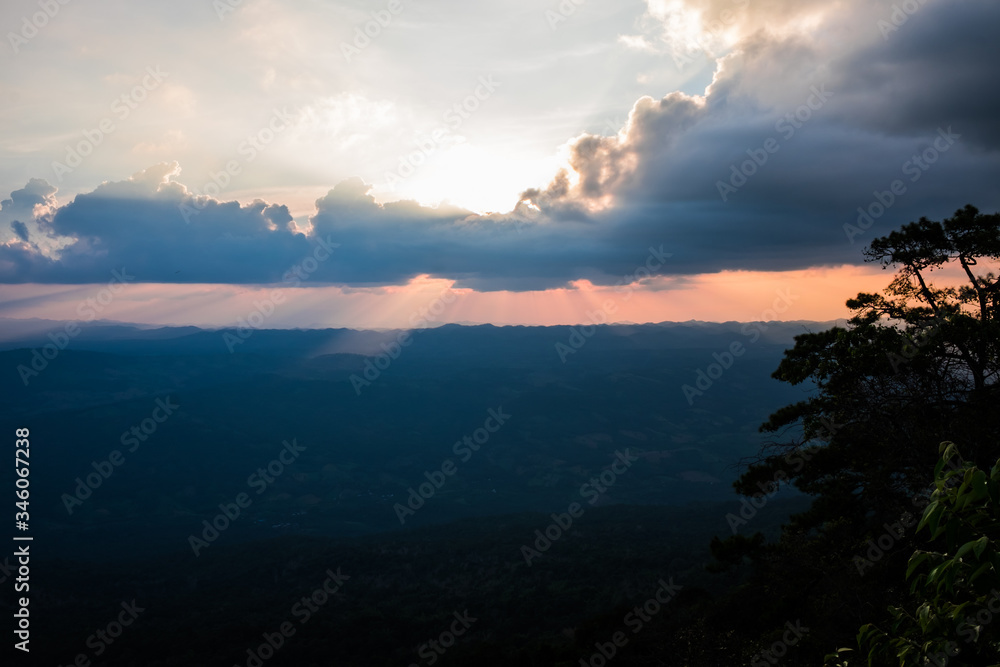 Sunlight through the dark clouds on the mountain complex. Phu Kradueng National Park ,Thailand