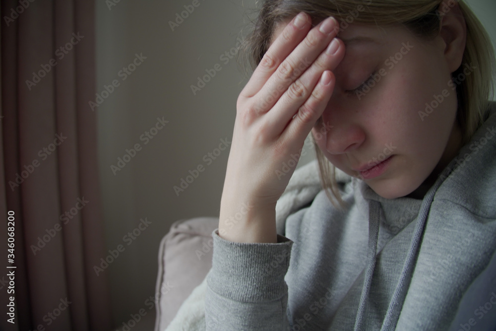 close up of Sick woman with a headache sitting on a sofa close up of Sick woman with a headache sitting on a sofa