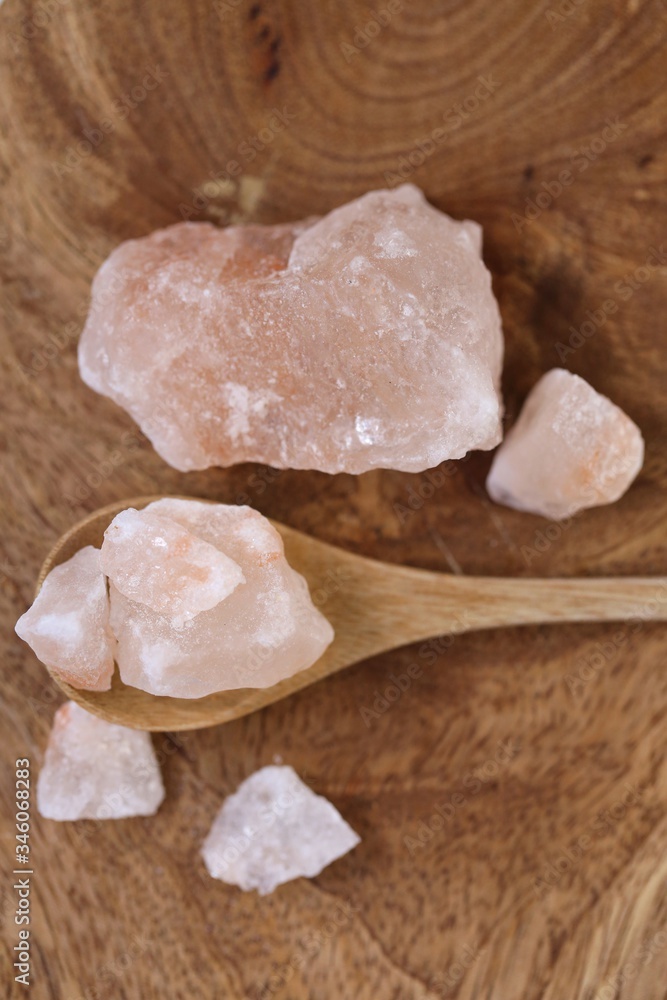 Pink Himalayan salt in a wooden spoon on a wooden board. Super food.Himalayan salt Large crystals Pink Himalayan salt in a wooden spoon on a wooden board. Super food.Himalayan salt Large crystals