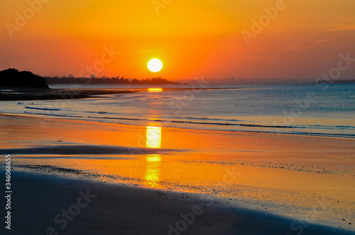 A beautiful sunset over the beach with reflection in Kigamboni Tanzania photo