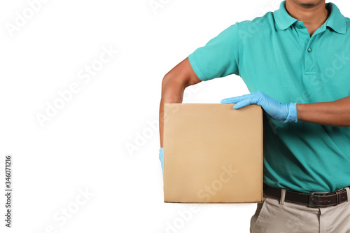 Delivery man wearing green shirts holding cardboard boxes on his side in medical rubber gloves. Online shopping and Express delivery concept.