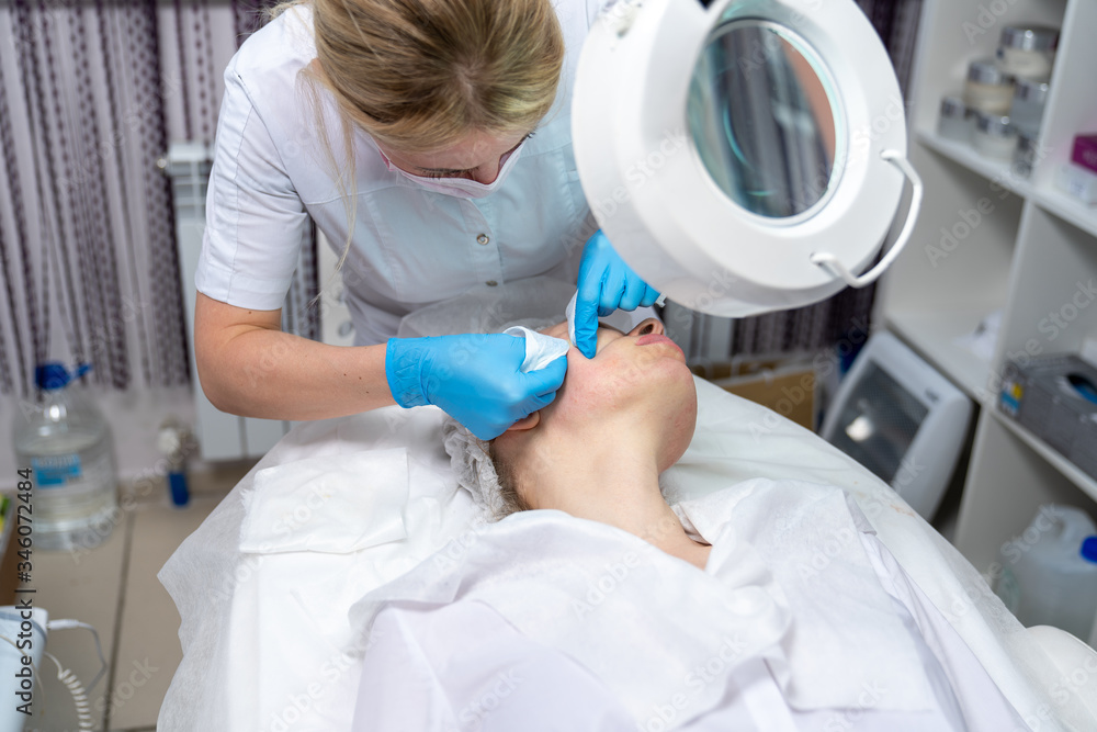 Beautician does facial skin cleansing for his client. Cleansing the skin with special tools. Facial cleansing mask. Beautician does facial skin cleansing for his client. Cleansing the skin with special tools. Facial cleansing mask.