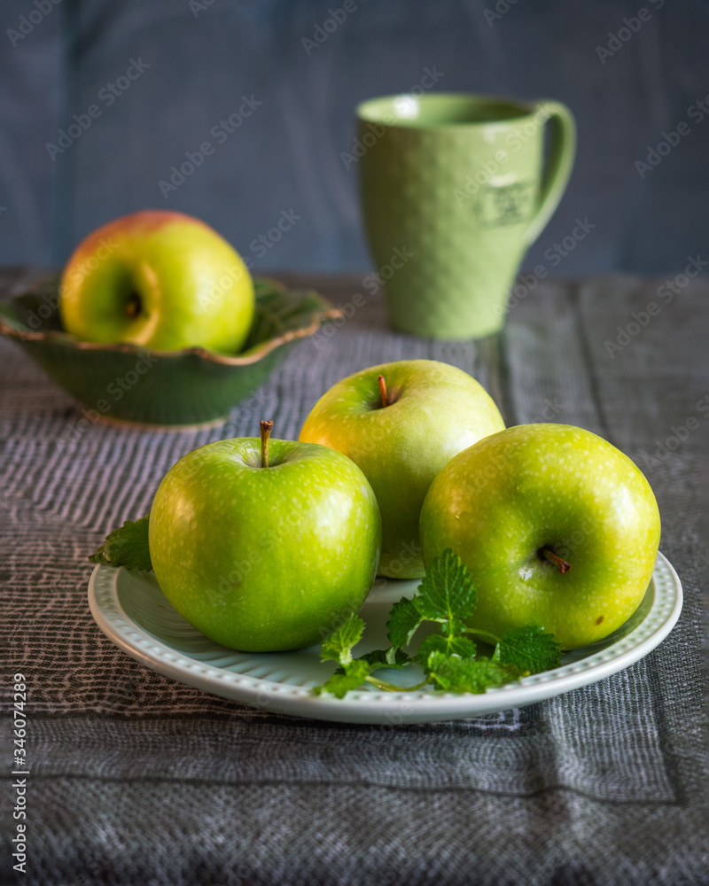 Green apples on a table covered with a green tablecloth Green apples on a table covered with a green tablecloth