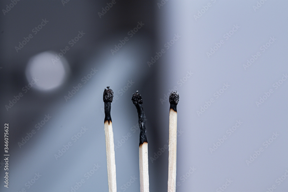 Three burnt black match sticks in a row close up still Three burnt black match sticks in a row close up still