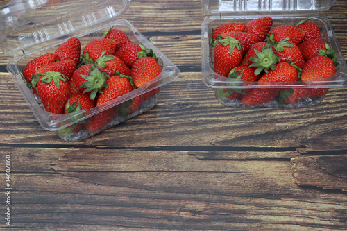 Fresh strawberries placed on a wood grain table top view .