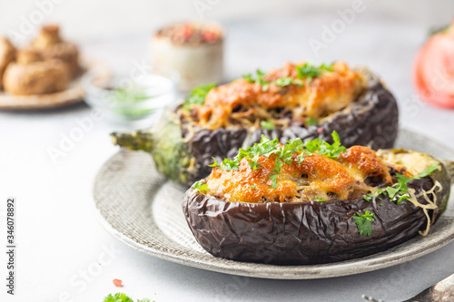 Baked aubergine or eggplant boats stuffed with mushrooms, vegetables and cheese