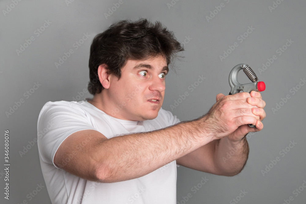 Young man is losing weight. Positive man goes in for sports with dumbbell. Tired of sports man. Young man is losing weight. Positive man goes in for sports with dumbbell. Tired of sports man.