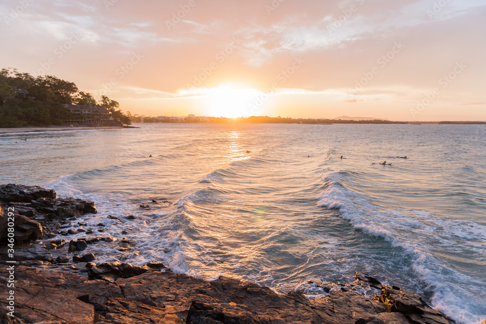 Obraz premium Colourful sunset and sky at the shore. Big and bright sun hiding in the sea. Waves crashing the rocks. Horizontal