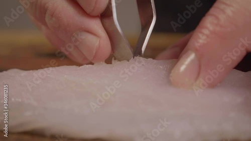 Australasian Snapper being prepared for cooking - Pin bones being removed photo