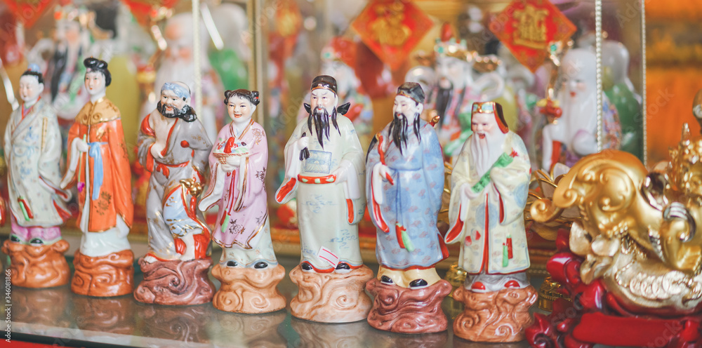 Chinese pottery doll. A roll of traditional Chinese pottery dolls - common home decorations and souvenirs with soft focus on the Chinese girl in pink traditional costume.